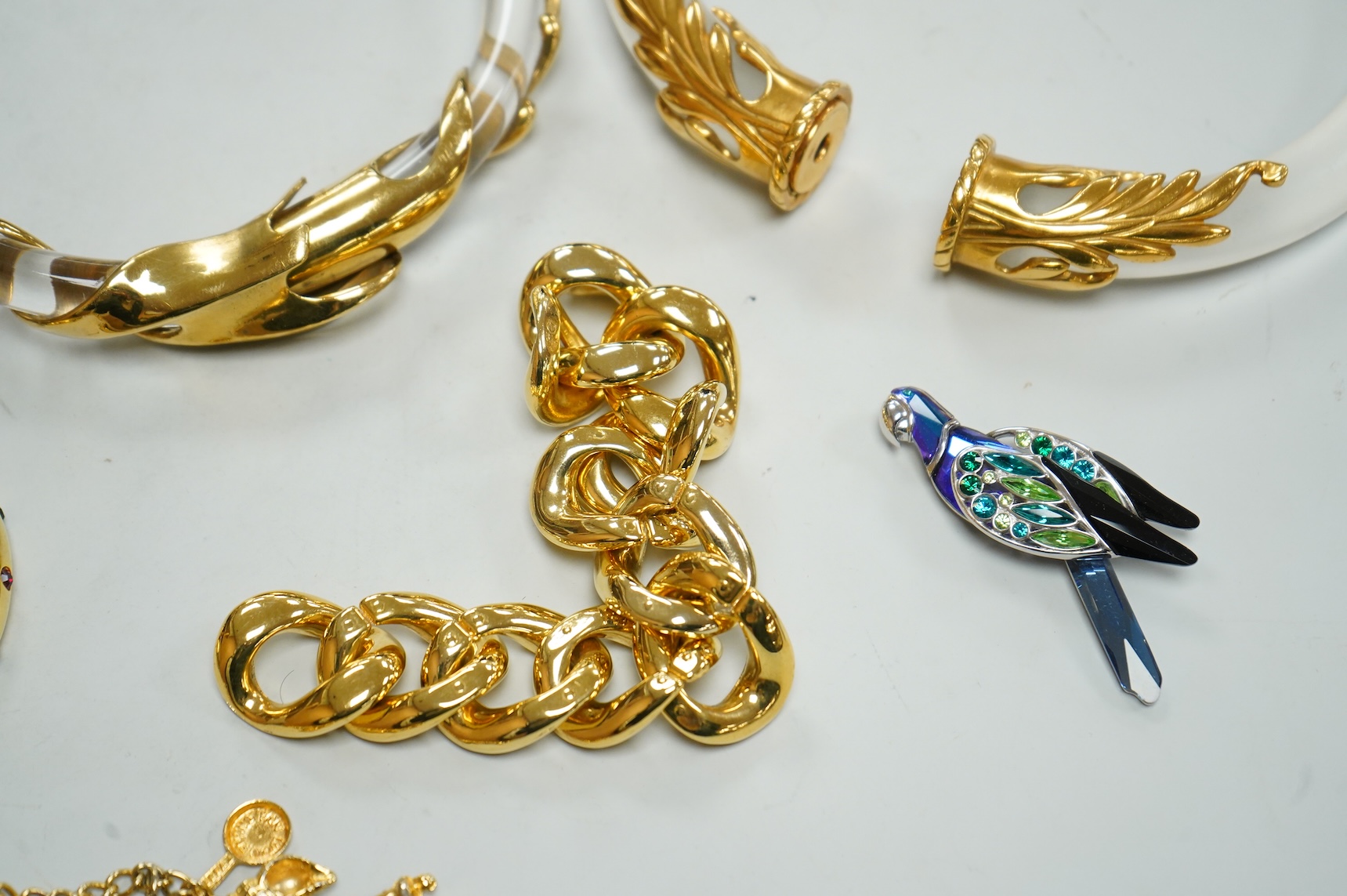 A small group of assorted costume jewellery including a 925 and paste set brooch and pair of ear clips and a gilt metal charm bracelet.